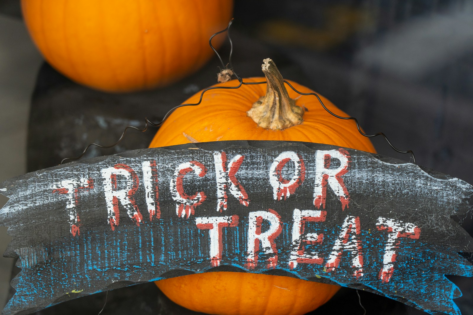 Two pumpkins beside a “Trick or Treat” sign on a front porch, symbolizing safe and welcoming Halloween fun for Alabama and Georgia families.
